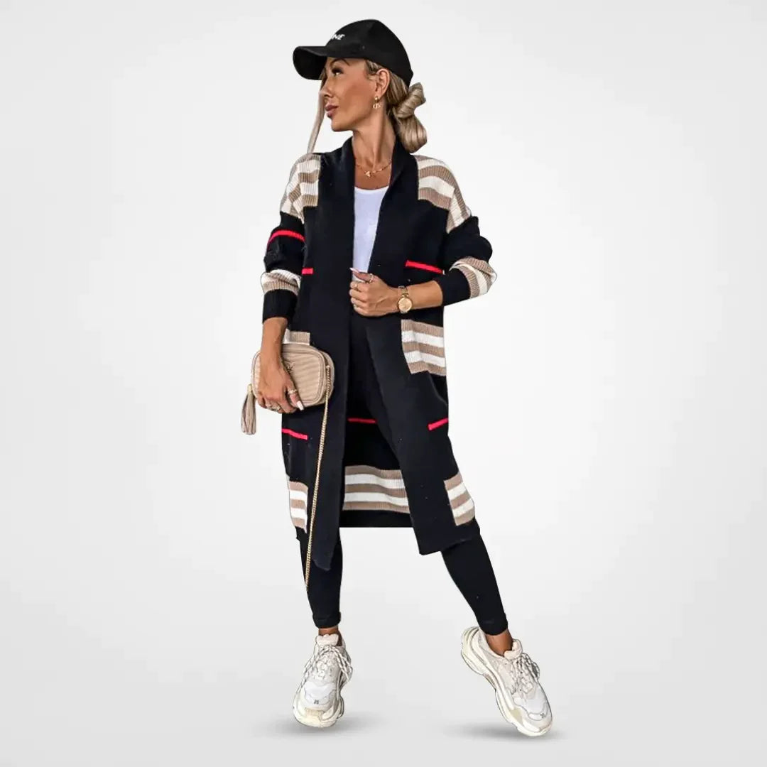 Claire striped longline cardigan in black with beige stripes and pink accent, worn with black leggings, front view