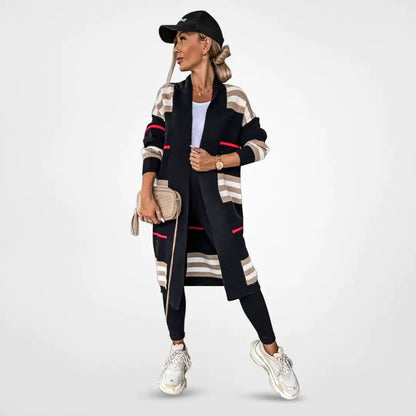 Claire striped longline cardigan in black with beige stripes and pink accent, worn with black leggings, front view