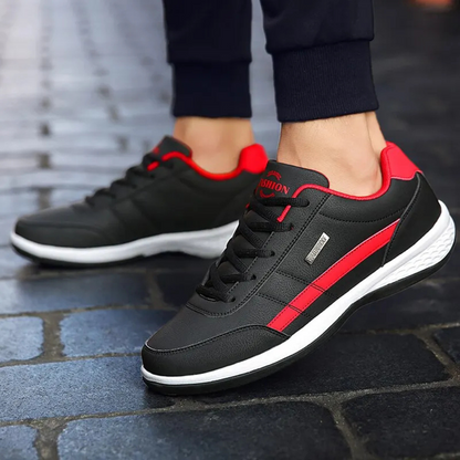 Navy leather trainer with tan stripe detail and waterproof label held in hand