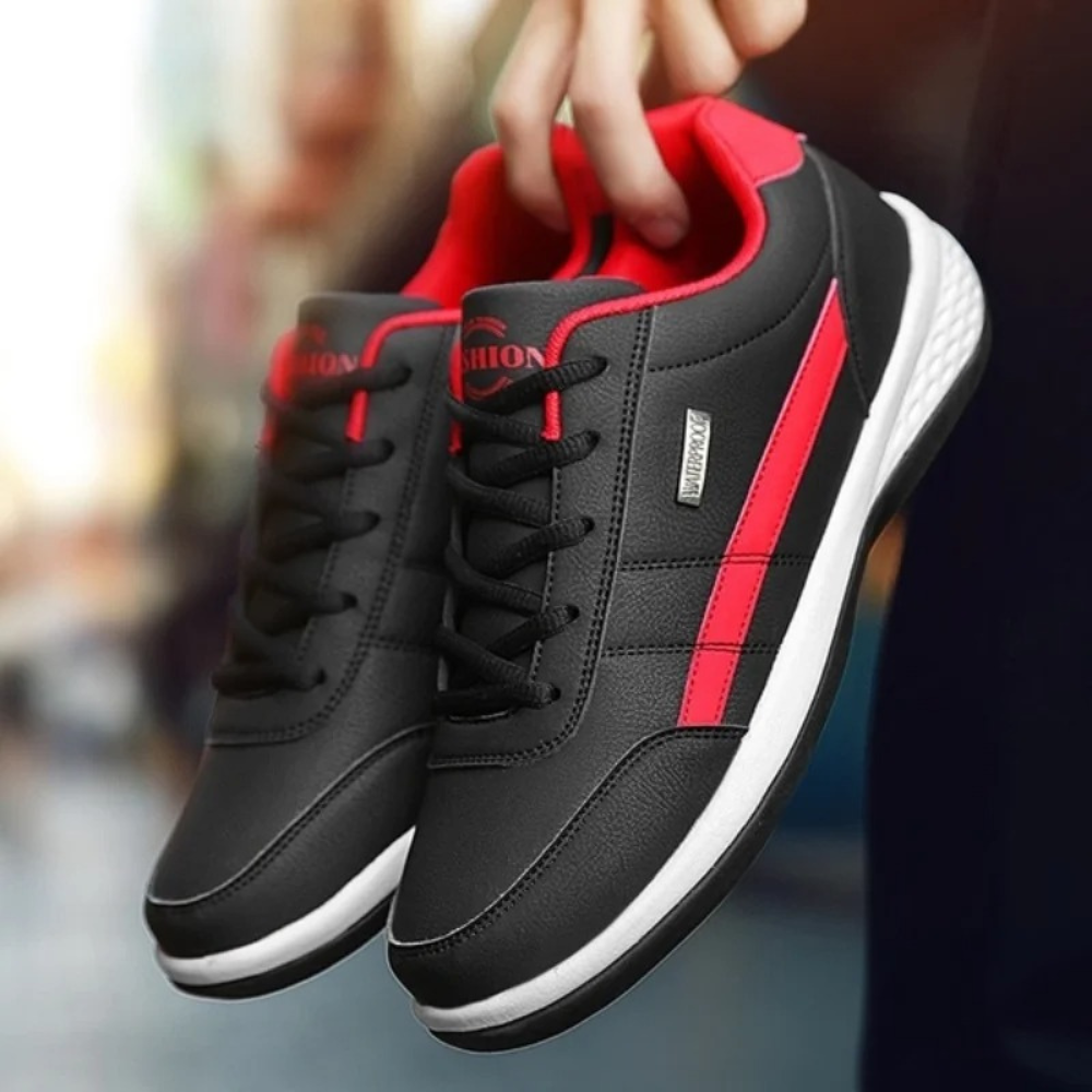 White lace-up trainers with black heel tab held in hand, side profile