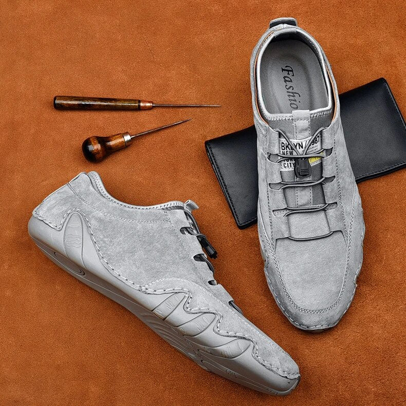 Jasper slip-on trainers displayed flat with leathercraft tools, showing outsole detail