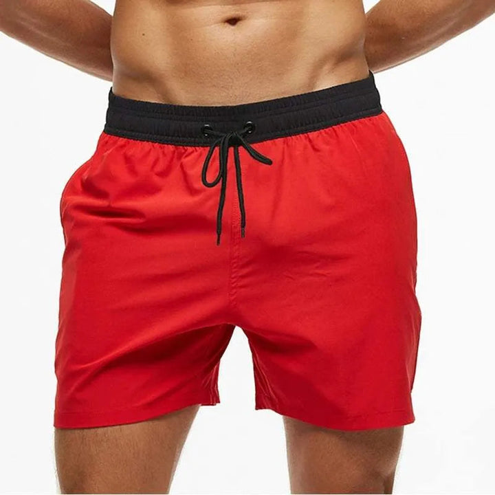 Kai red swim shorts with black waistband, front view