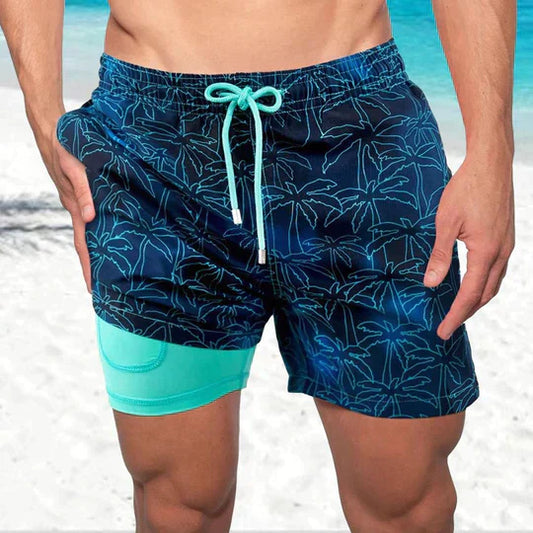 Noah printed swim shorts with teal drawstring, front view on beach
