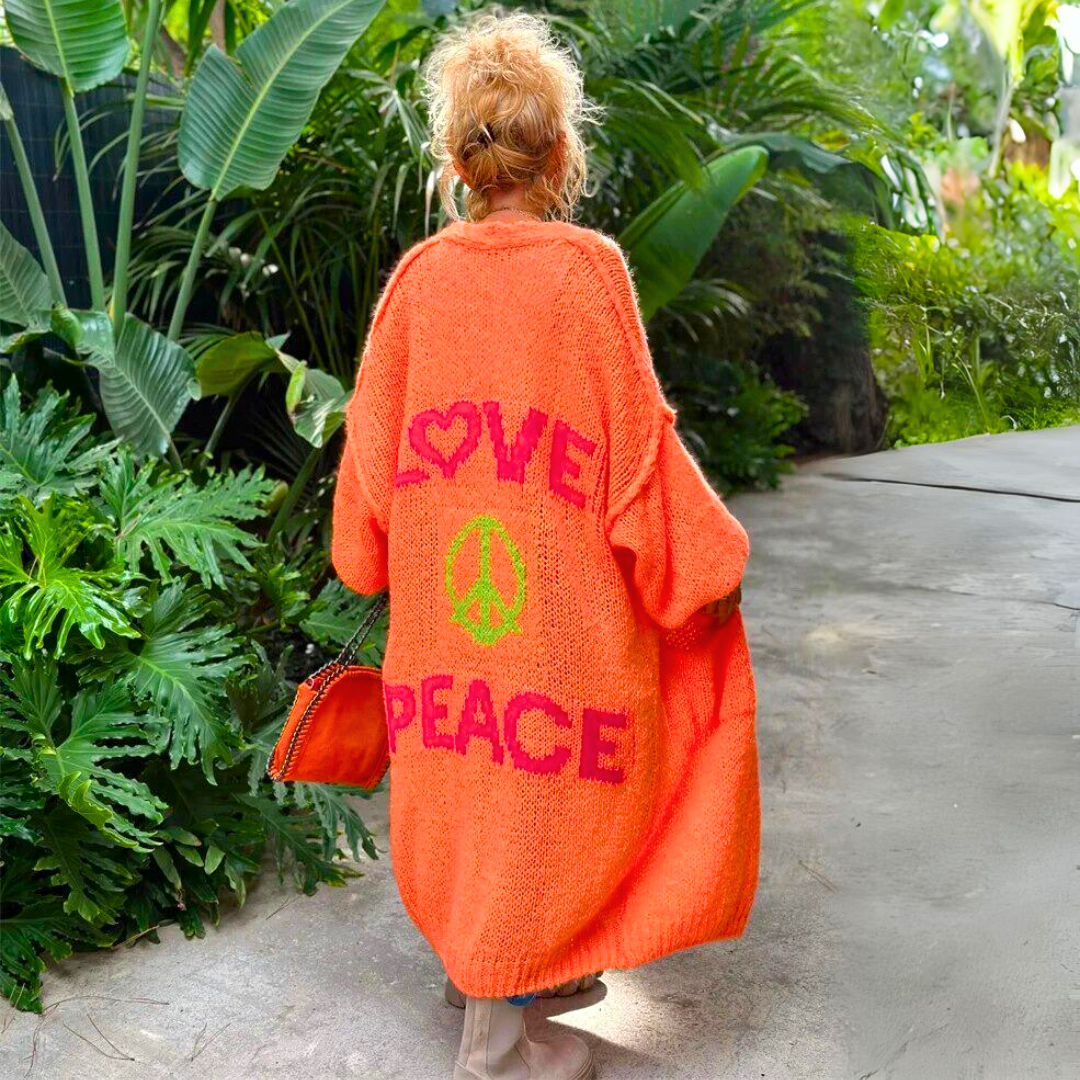 Poppy orange slogan print maxi cardigan, back view in tropical garden